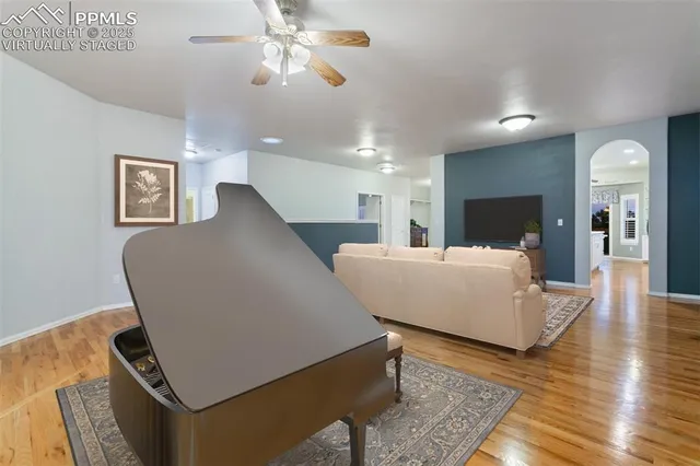 a living room with stainless steel appliances kitchen island granite countertop furniture wooden floor and a kitchen view