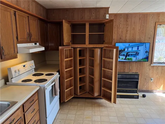 a view of an empty room with cabinet and a window