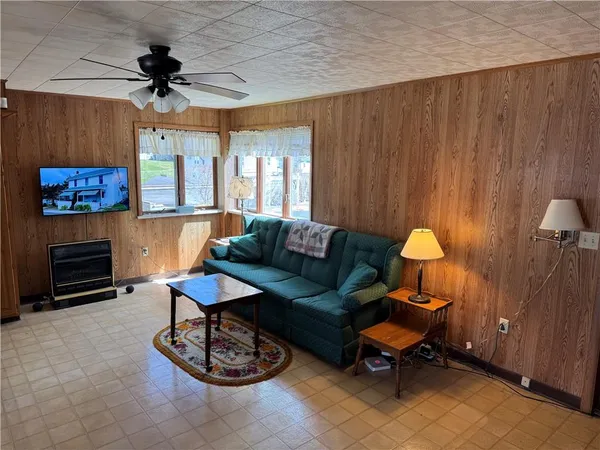 a living room with furniture a flat screen tv and a table