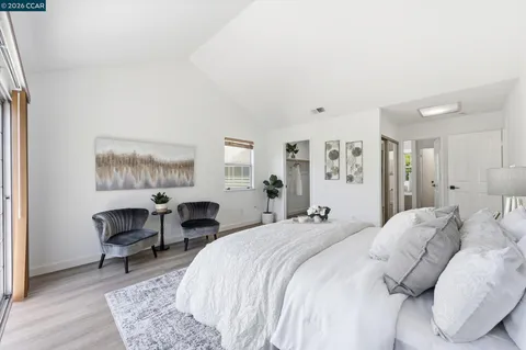 a spacious bedroom with a bed a table and chair