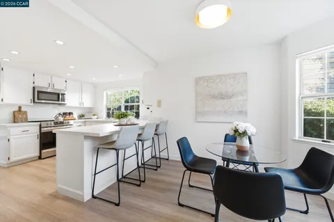 a kitchen with a dining table chairs and window