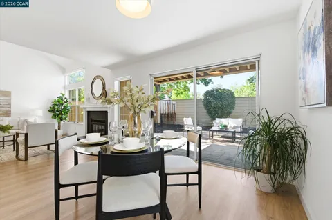 a dining room with furniture a fireplace and wooden floor