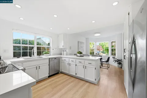 a large white kitchen with a large window