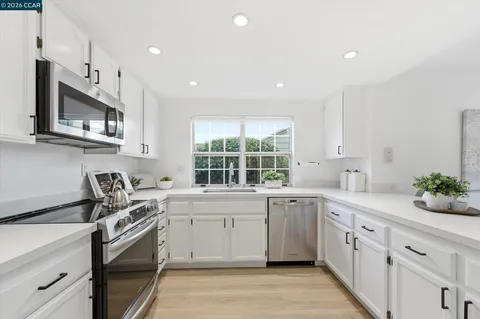 a kitchen with a sink stove oven and window