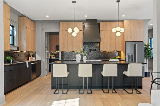 a kitchen with stainless steel appliances granite countertop a refrigerator and a sink