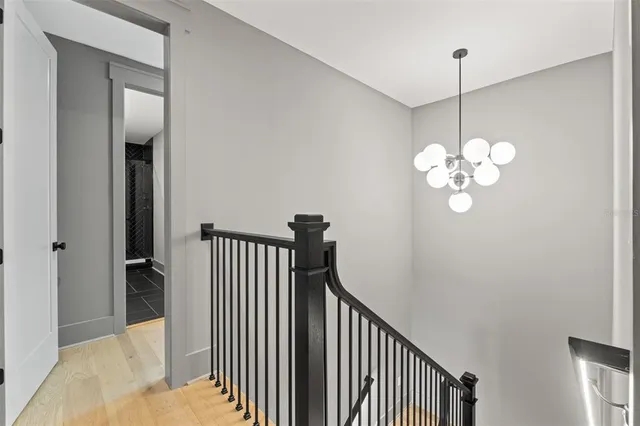 a view of a hallway with a chandelier fan and livingroom view