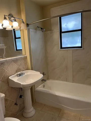 a bathroom with a sink mirror and a bath tub
