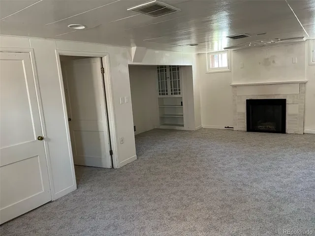 an empty room with furniture and a fireplace