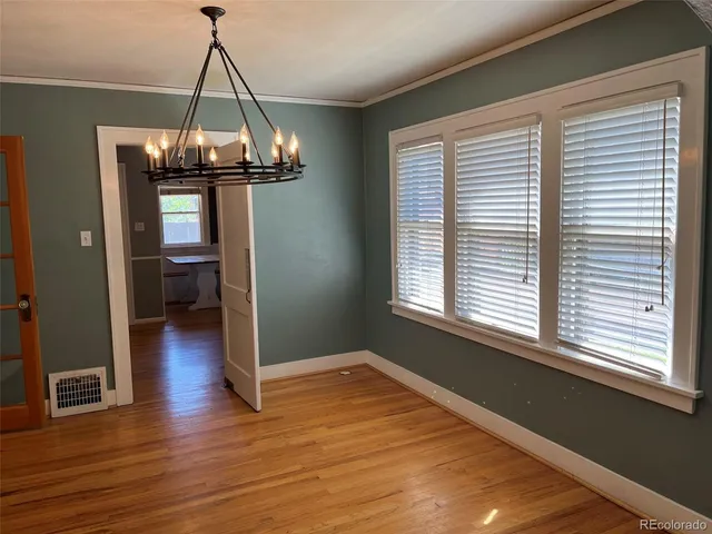 a view of a room with wooden floor staircase and a kitchen