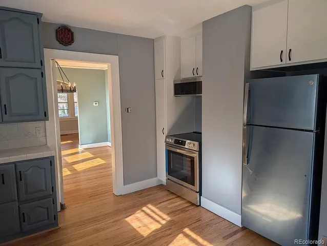 a kitchen with a refrigerator and a stove top oven
