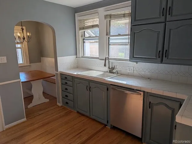 a kitchen with a sink cabinets and wooden floor