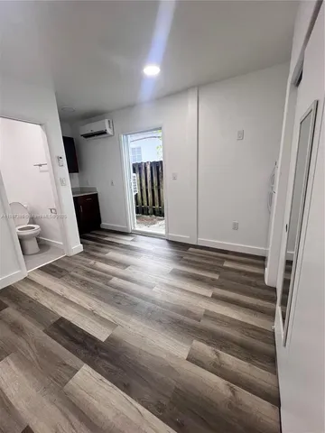 a view of a livingroom with wooden floor and staircase