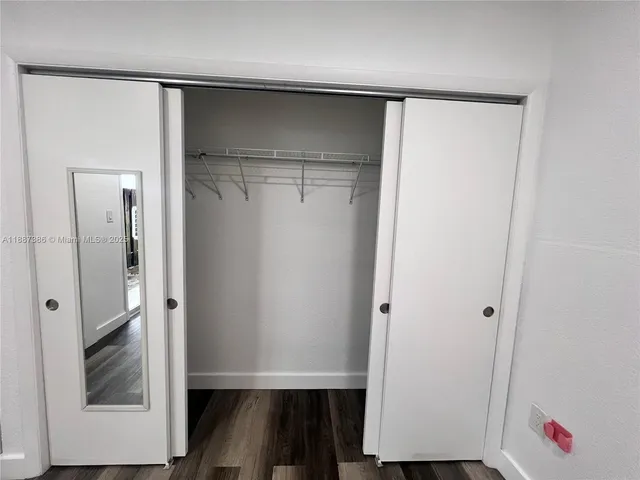 a view of closet with wooden floor