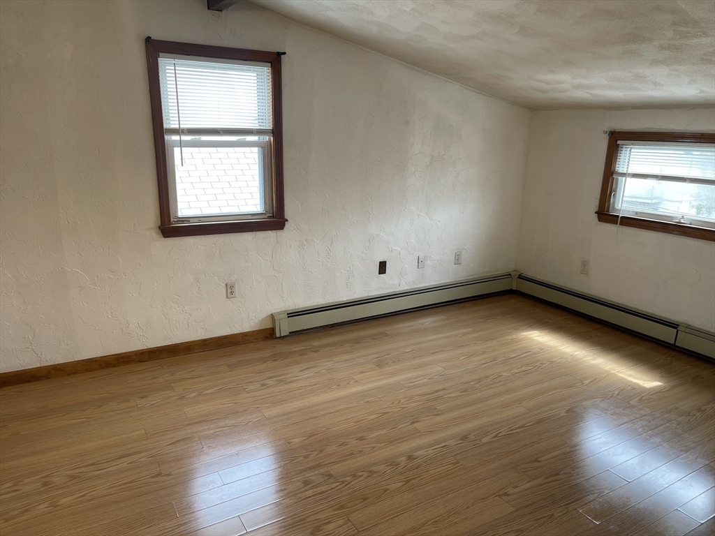 9 Gilmore Street, Unit 3 Everett, MA 02149 - Photo 7 of 11 an empty room with wooden floor and windows