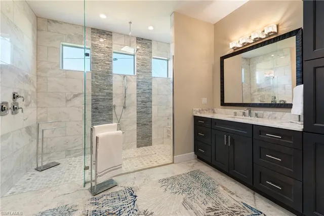 a bathroom with a granite countertop sink a mirror and a shower