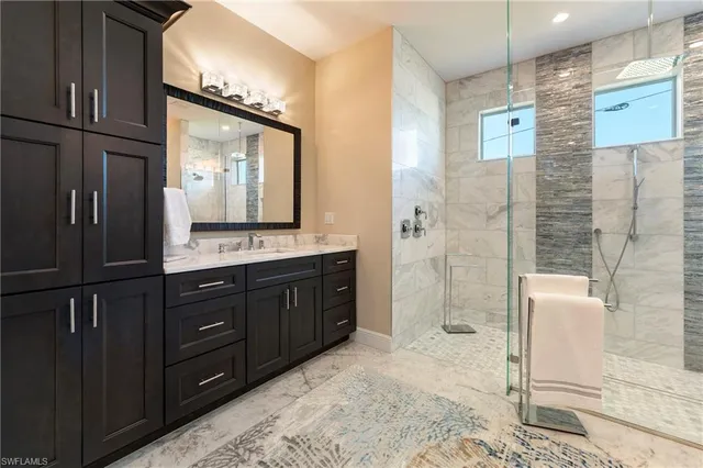 a bathroom with a granite countertop sink mirror and shower