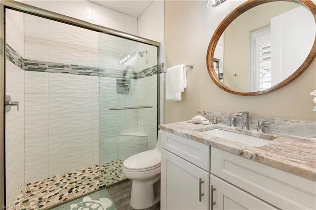 a bathroom with a granite countertop sink toilet and shower