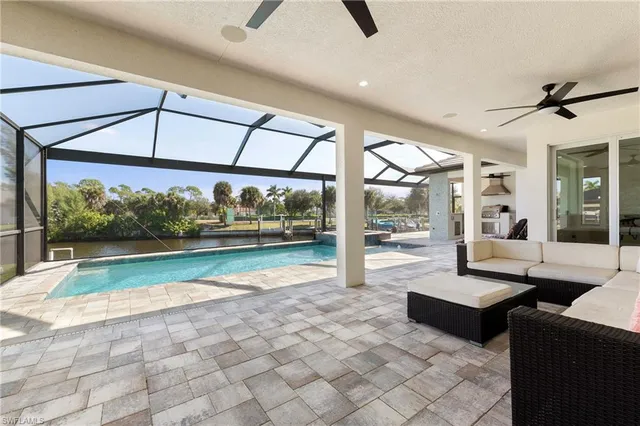 a living room with couch floor to ceiling windows and a ceiling fan