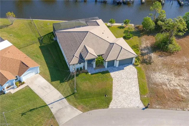 an aerial view of a house with swimming pool and large trees