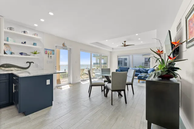 a dining room with furniture potted plants and wooden floor
