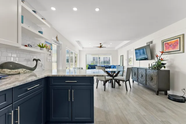 a kitchen with granite countertop a sink dining table and chairs