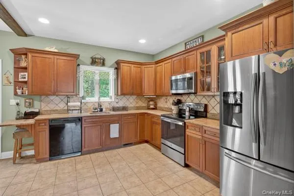 a large kitchen with cabinets chairs and a sink