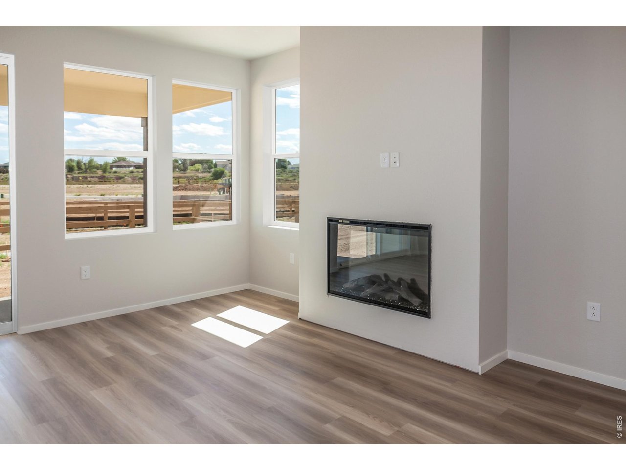 792 Chatter Road Windsor, CO 80550 - Photo 25 of 49 a view of an empty room with wooden floor and a window