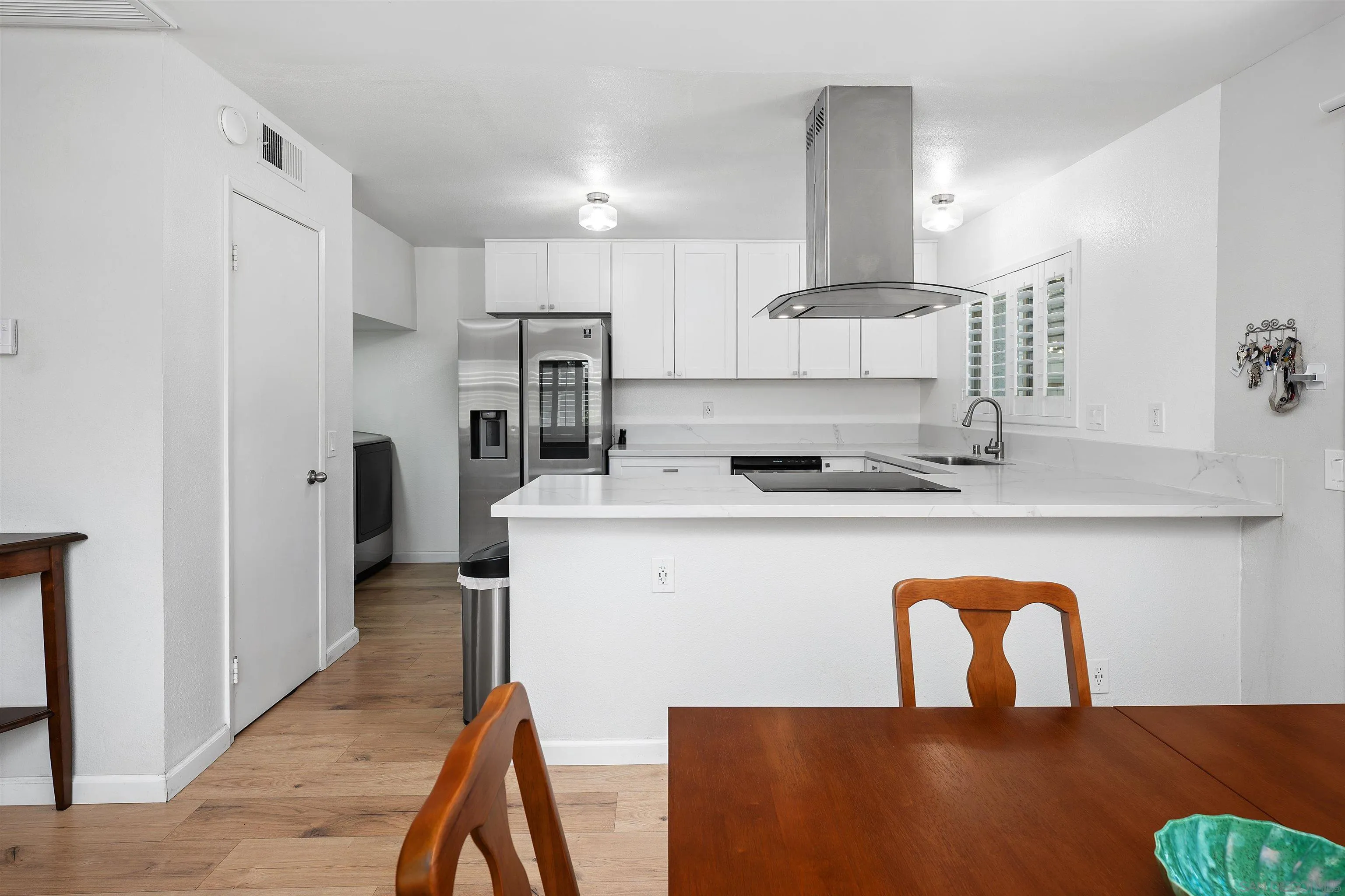 8325 Panorama Ridge Court Spring Valley, CA 91977 - Photo 16 of 39 a close view of a kitchen island with furniture a refrigerator and wooden floor