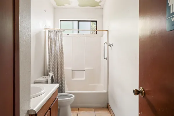 a bathroom with a sink a toilet a mirror and shower