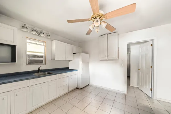 a kitchen with a sink a refrigerator and cabinets