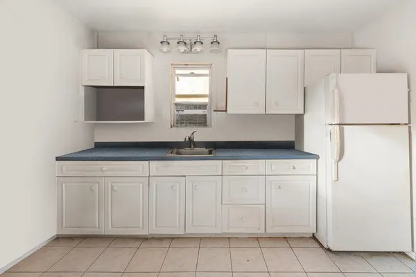 a kitchen with white cabinets and white appliances