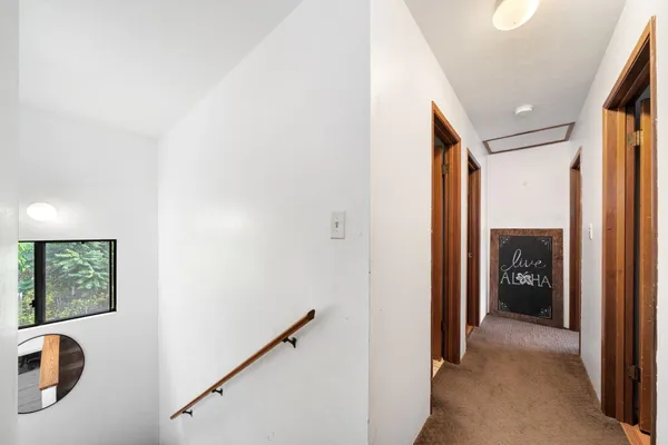 a view of a hallway with closet and a window