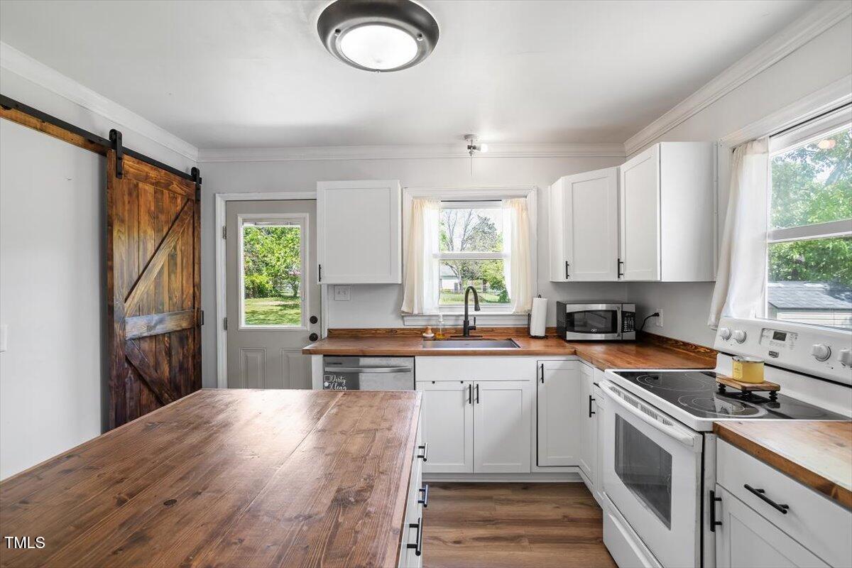 1017 Southerlund Road Garner, NC 27529 - Photo 2 of 26 a kitchen with a sink stove and cabinets