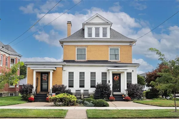 front view of a brick house with a yard