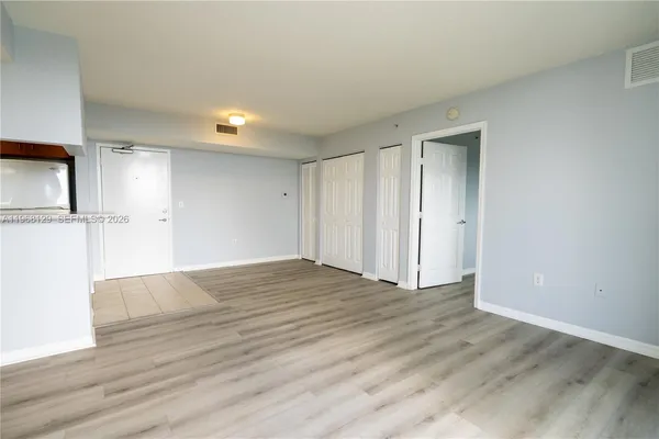 a view of empty room with wooden floor