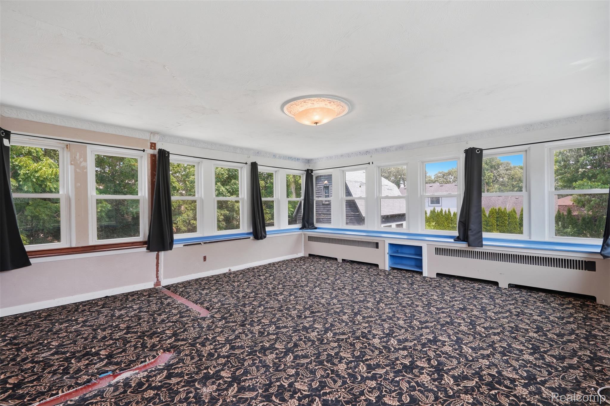 31000 Drake Road Farmington, MI 48331 - Photo 22 of 44 Sunroom featuring extensive window placement, patterned carpeting, built-in shelving, and a flush mount ceiling light fixture