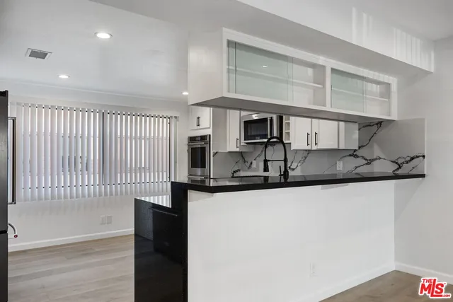a kitchen with stainless steel appliances granite countertop a sink and a stove top oven