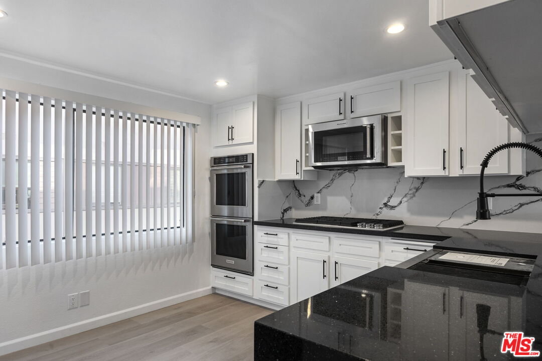 4631 Alla Road, Unit 8 Marina del Rey, CA 90292 - Photo 16 of 29 a kitchen with stainless steel appliances kitchen island granite countertop a stove a sink and a microwave