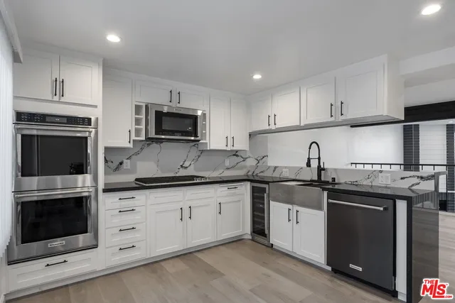 a kitchen with granite countertop a stove sink and cabinets