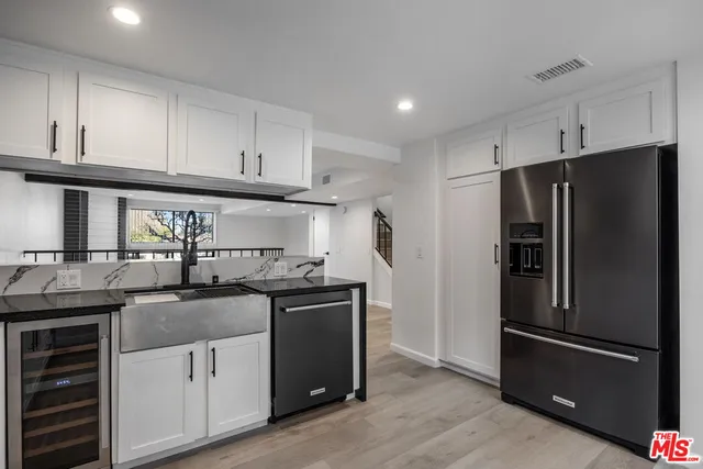 a kitchen with granite countertop a refrigerator stove and sink