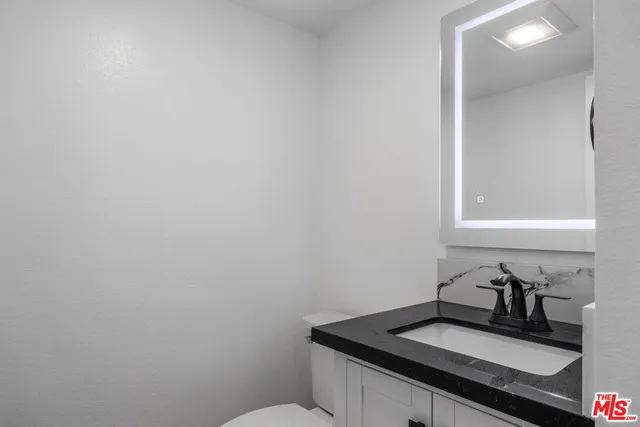a bathroom with a sink a toilet and mirror