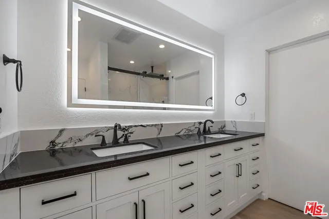 a bathroom with a granite countertop sink a large mirror and a