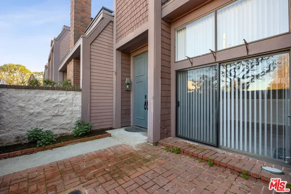 a view of a house with a small yard and wooden floor and fence