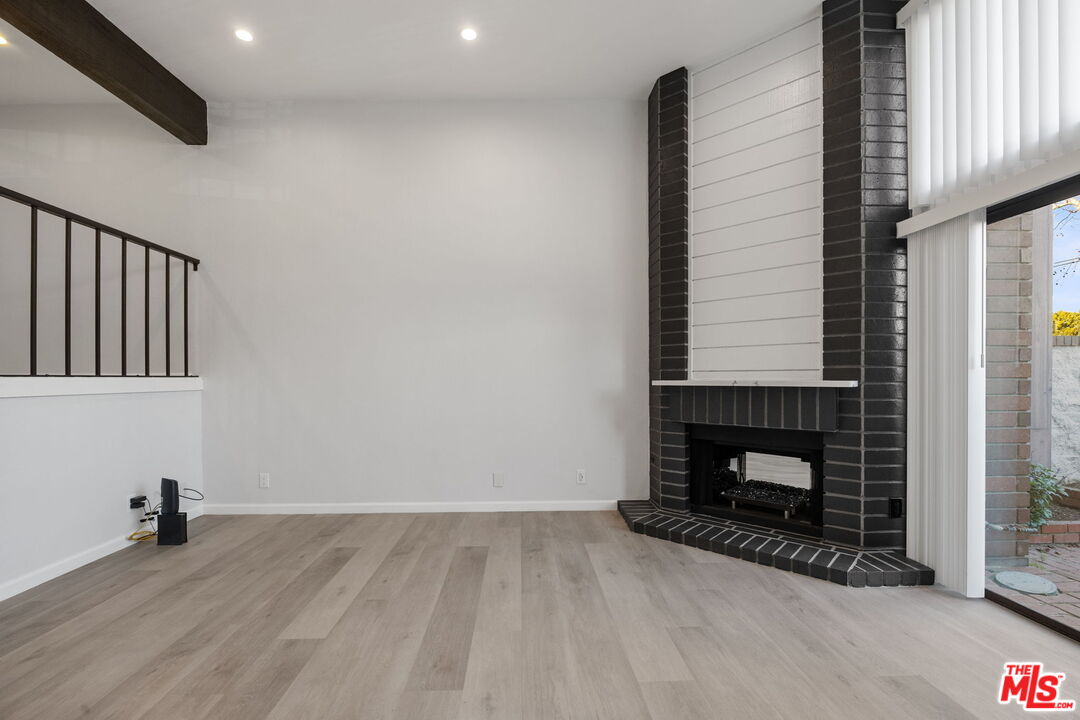 4631 Alla Road, Unit 8 Marina del Rey, CA 90292 - Photo 8 of 29 a view of an empty room with wooden floor and a fireplace