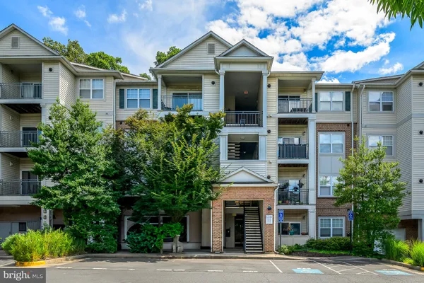 a front view of a residential apartment building with a yard and garage