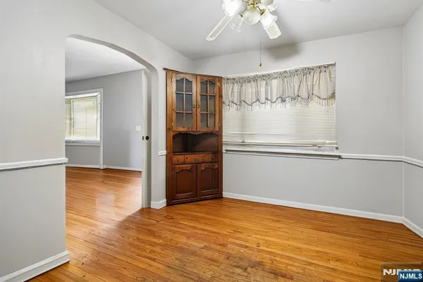 a view of empty room with wooden floor and window