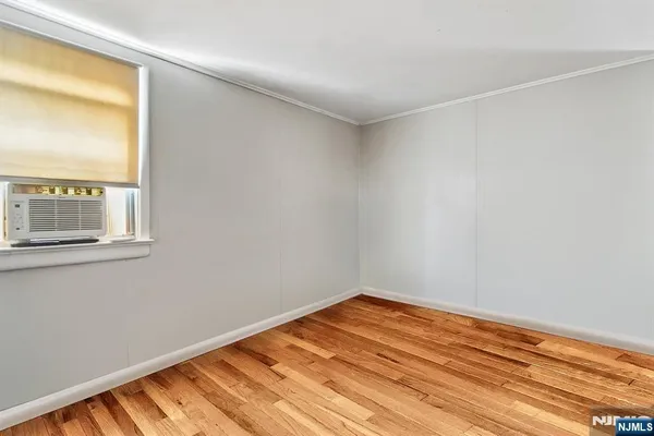a view of a room with wooden floor and a window