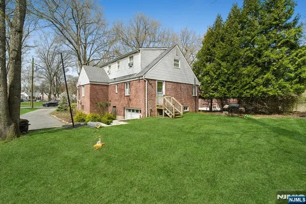 a view of a back yard of the house with a large tree