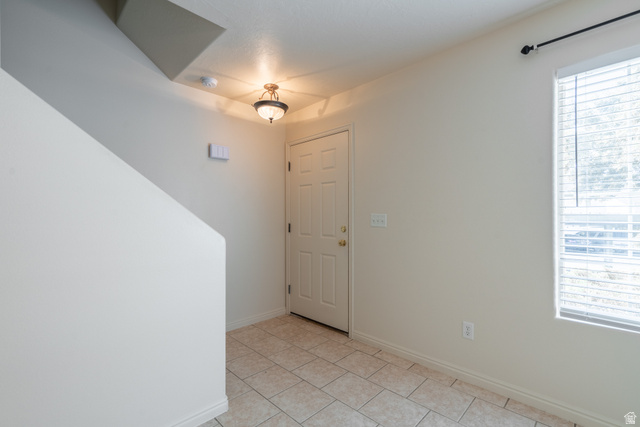 1735 West 540 North, Unit 1805 St. George, UT 84770 - Photo 7 of 64 Entryway featuring light-toned tile flooring, a white paneled entry door, a window with horizontal blinds, and a traditional ceiling light fixture