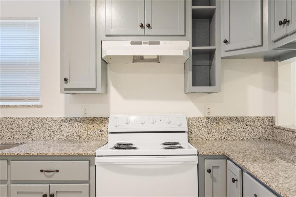 1120 Holt Avenue Waco, TX 76706 - Photo 10 of 25 a kitchen with granite countertop white cabinets and white appliances